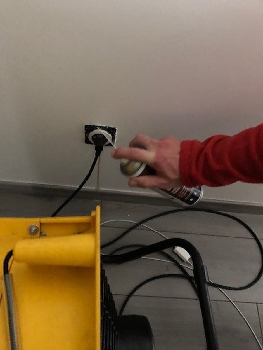 Un technicien en tenue rouge du réseau branche le générateur thermique jaune lors d'une intervention contre les punaises de lit.